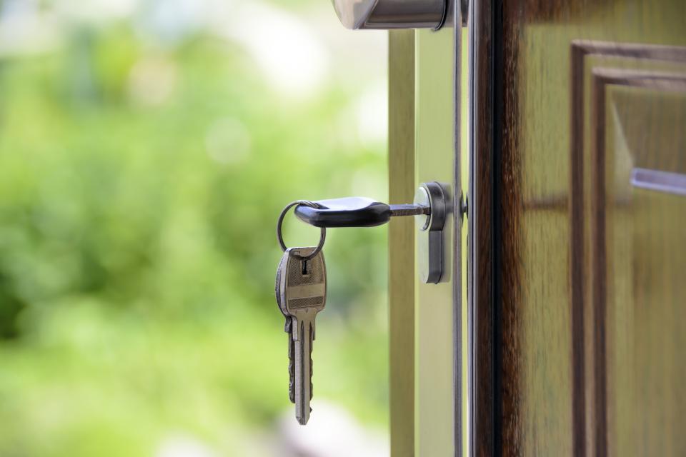 Should You Pay Off Your Mortgage Early? Pros, Cons and the Math House keys hanging in the lock of an open front door