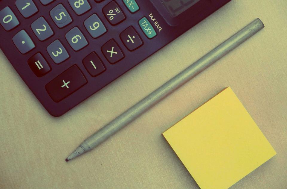 How to Calculate an Early Mortgage Payoff Calculator and pen resting on printed loan paperwork