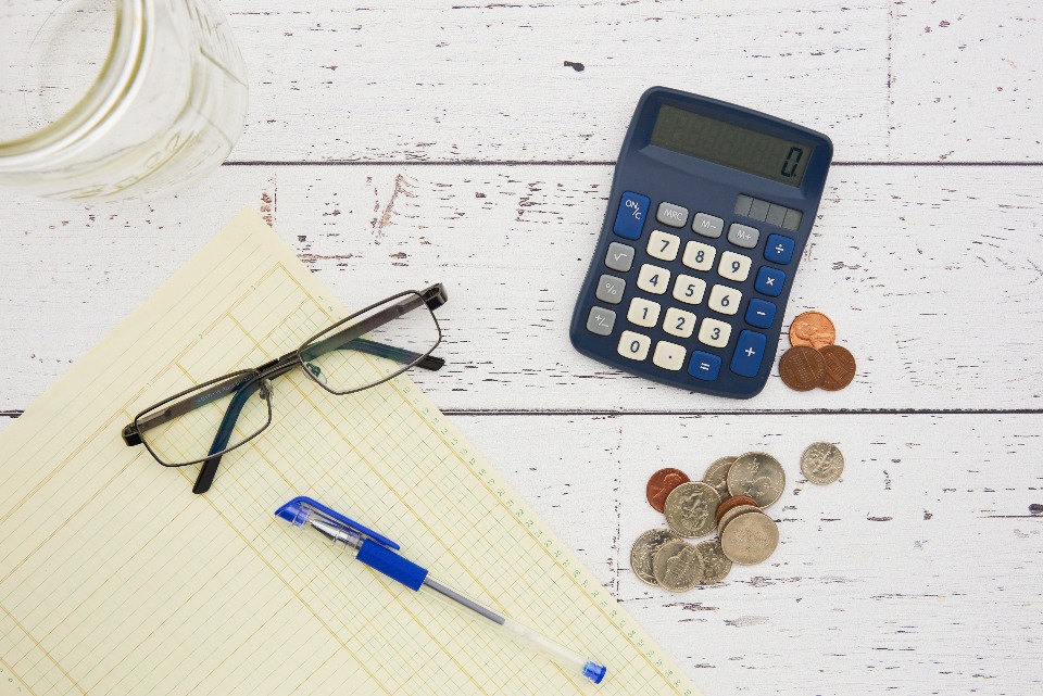 How to Refinance Student Loans Loan statements, a calculator and a laptop on a desk